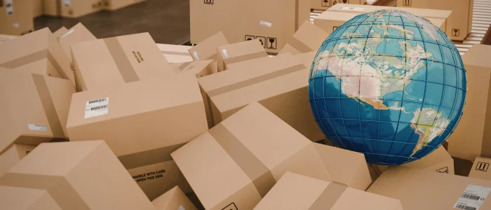 Cajas de mercancía con globo terráqueo, representación del impacto de las operaciones aduaneras en el comercio exterior global